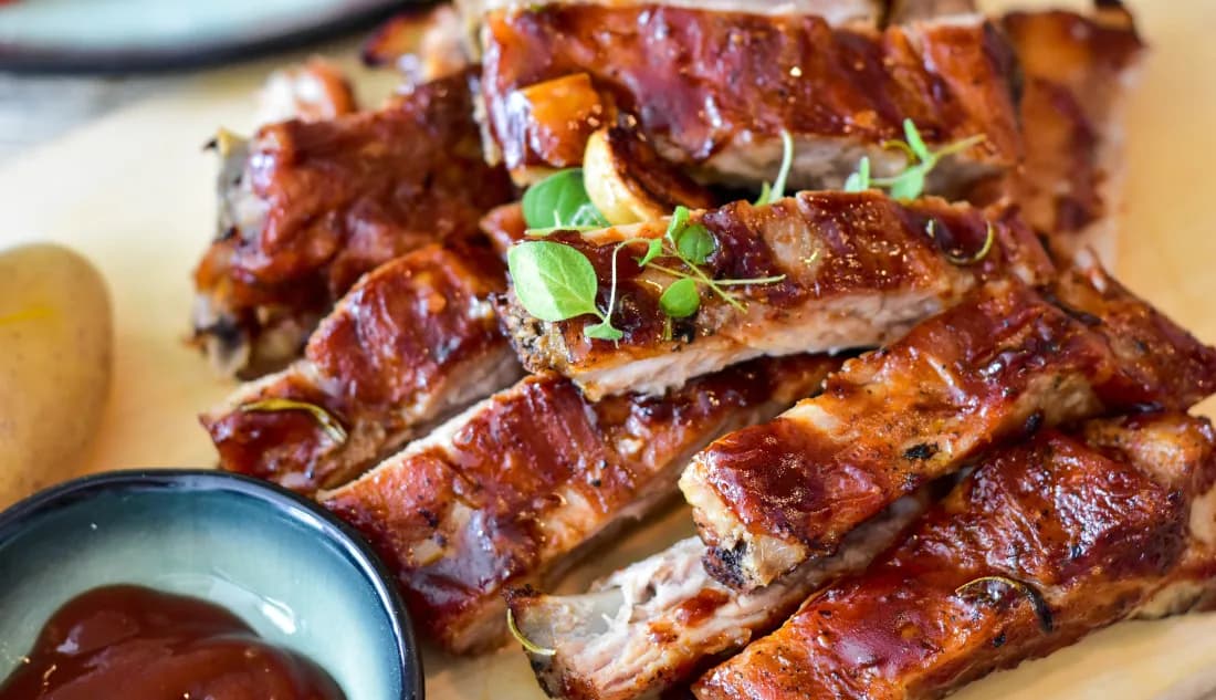 Barbecue pork ribs glazed with sauce and served with ketchup on a plate at a Branson restaurant.