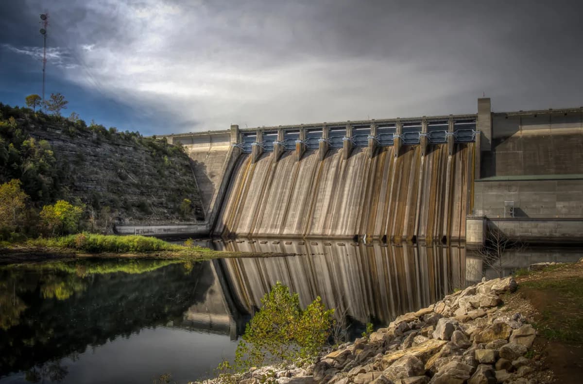 Concrete dam wall at Table Rock Dam reflecting on still water beneath a cloudy sky in the Ozarks.